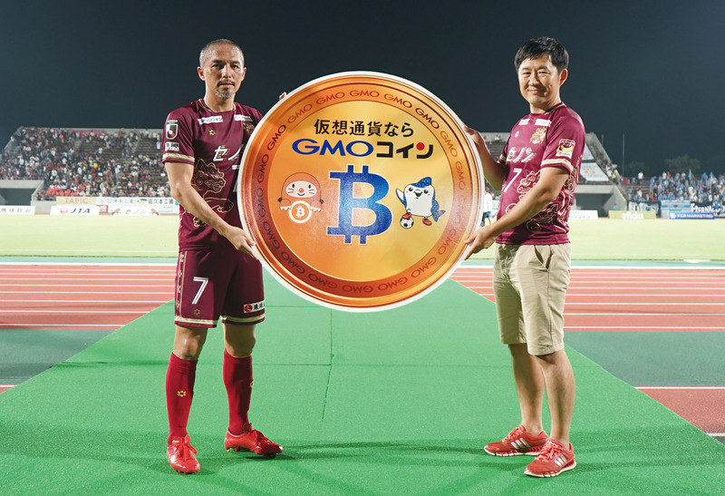 GMOコイン・石村富隆社長（写真右）から賞金を受け取るFC琉球・小野伸二選手（写真左）